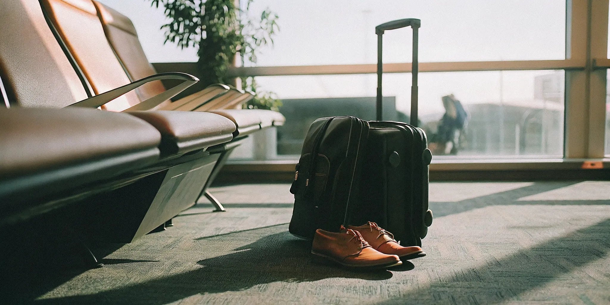 Grounding shoes beside carry-on luggage in an airport lounge