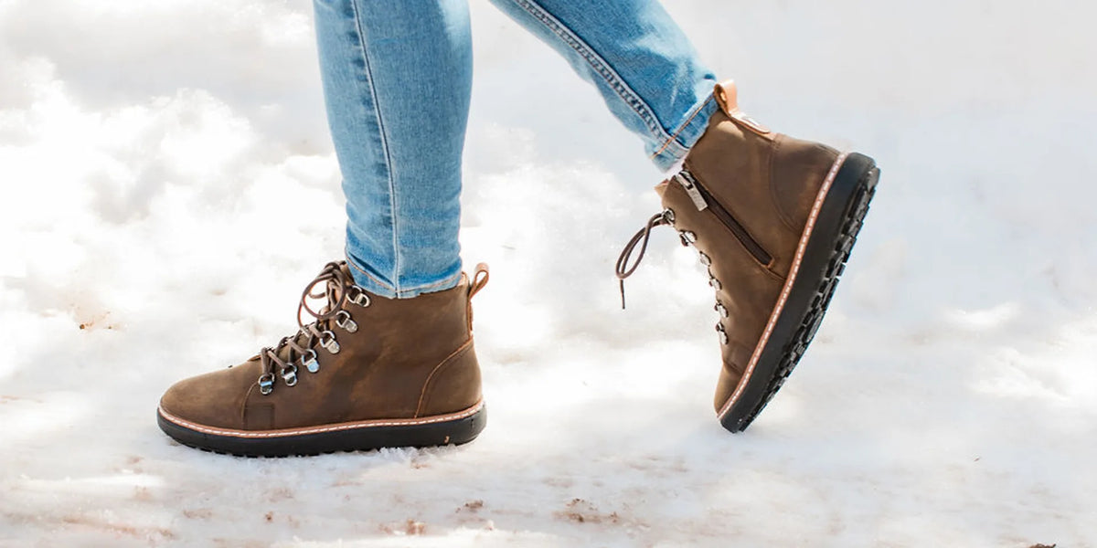 Brown grounding boots worn outdoors on a natural surface