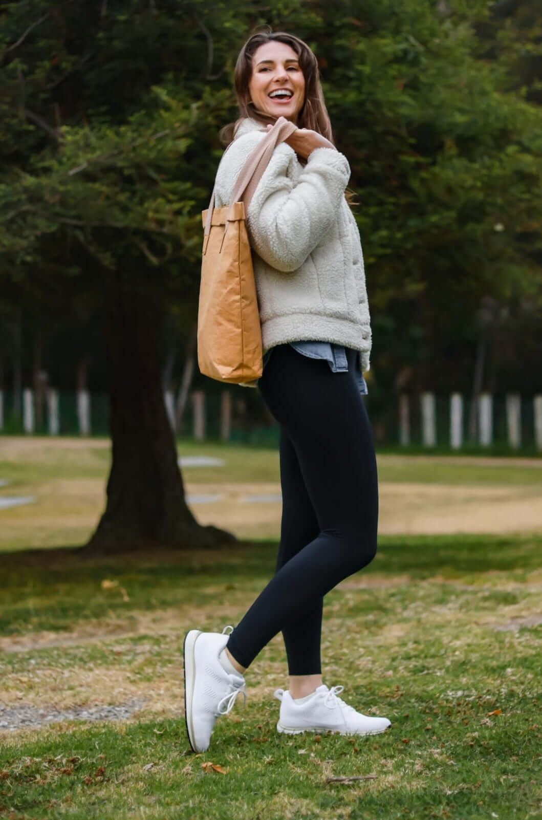 Woman wearing Harmony 783 Pamela White and Gold Knit Lace-Up for grounding and earthing in a park with a shopping bag
