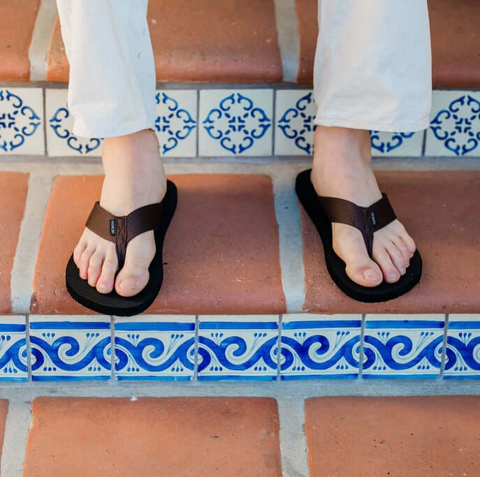 close up of man with feet on brick stairs wearing Harmony 783 Men’s Flip Flop Brown sandal conductive
footbed earthing