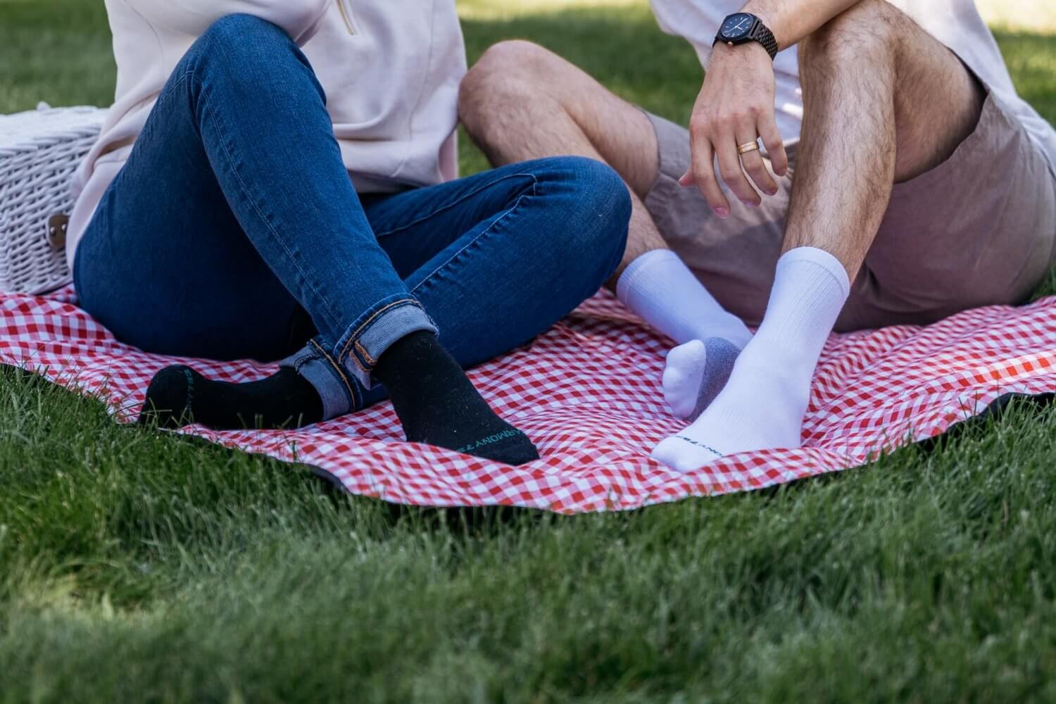 Close up Of man and woman Sitting ont he grass with Picnic blanket wearing Harmony 783 Crew Style Grounding Socks Black Merino Wool and White Organic Cotton with Silver Stitching conductive earthing socks
Lifestyle