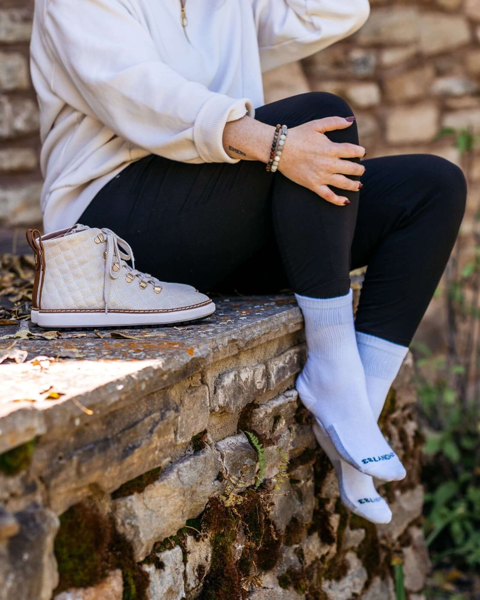 Close up o fwoman Sitting on stoneledge wearing Harmony 783 Crew Style Grounding Socks White Organic Cotton with Silver Stitching conductive earthing socks
Lifestyle1