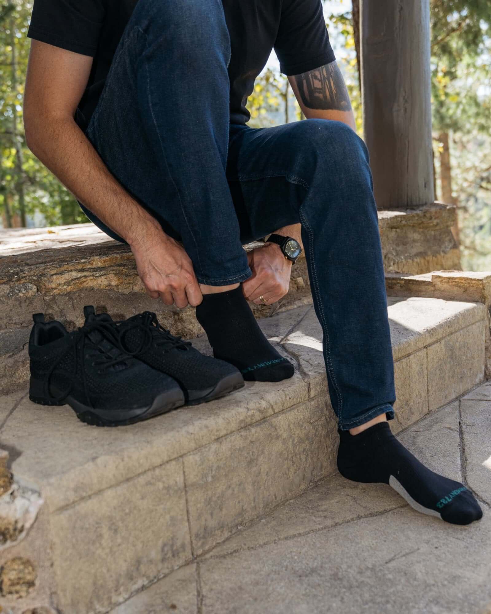Close up of Man Sitting on stone steps wearing Harmony 783 Grounding Socks Black Organic Cotton with Silver Stitching conductive earthing socks
Lifestyle