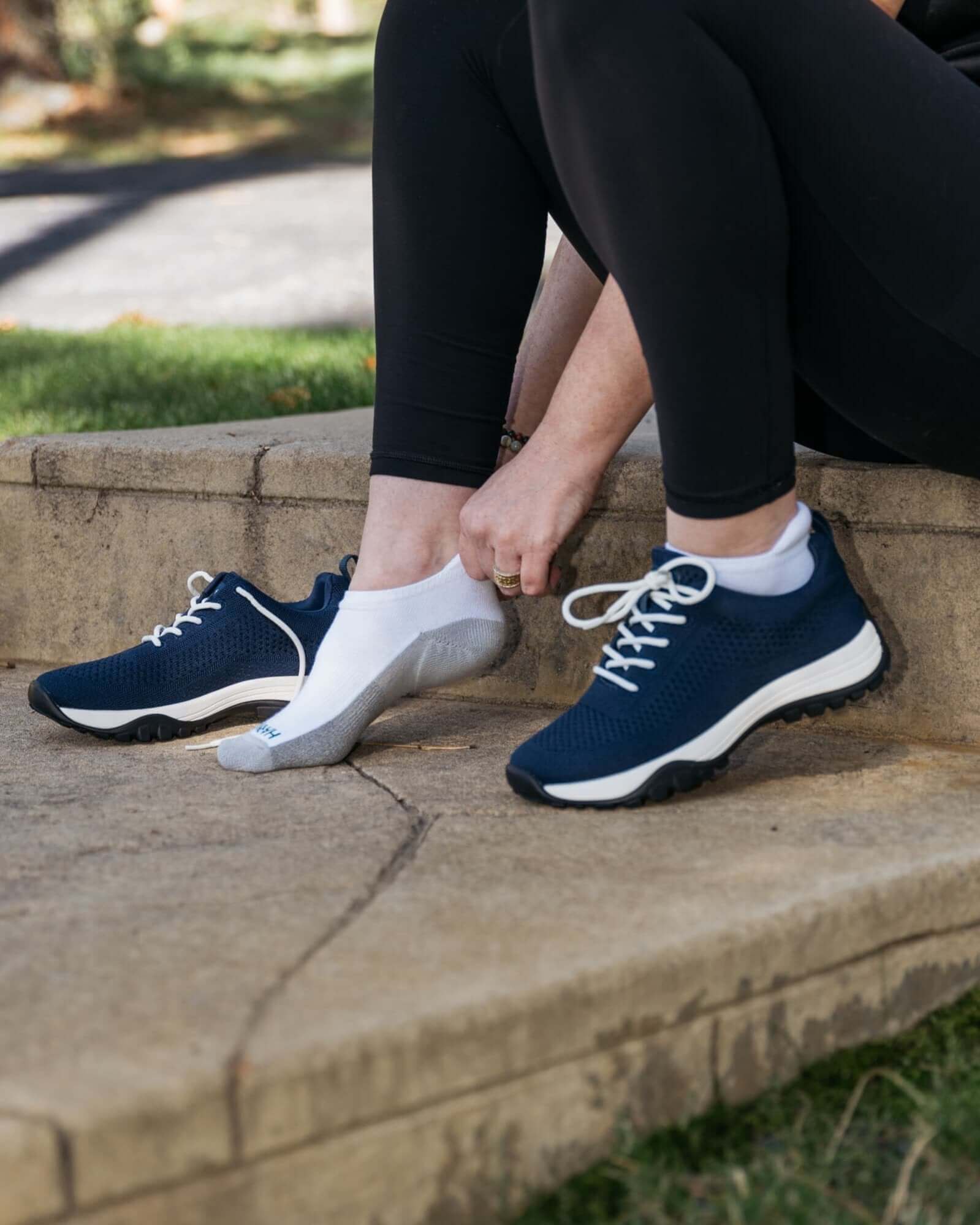 Close up of woman sitting on sstone step putting on Harmony 783 Low Cut Grounding earthing socks Organic Cotton and Silver Stitching
Lifestyle 1