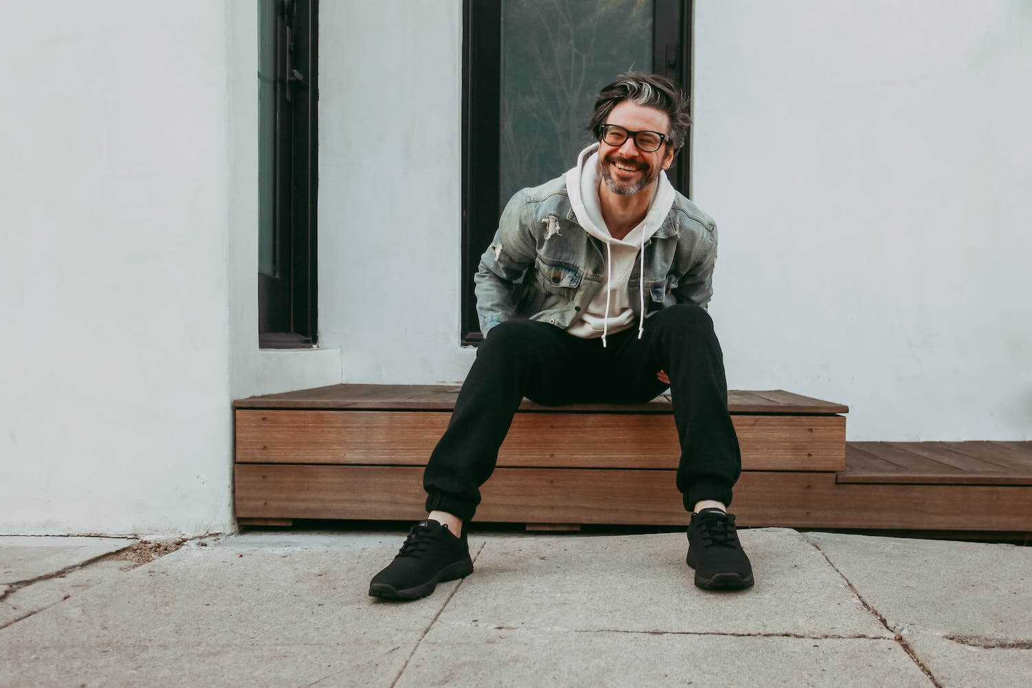 Lifestyle photo of man wearing black bamboo knit grounding sneakers n concrete