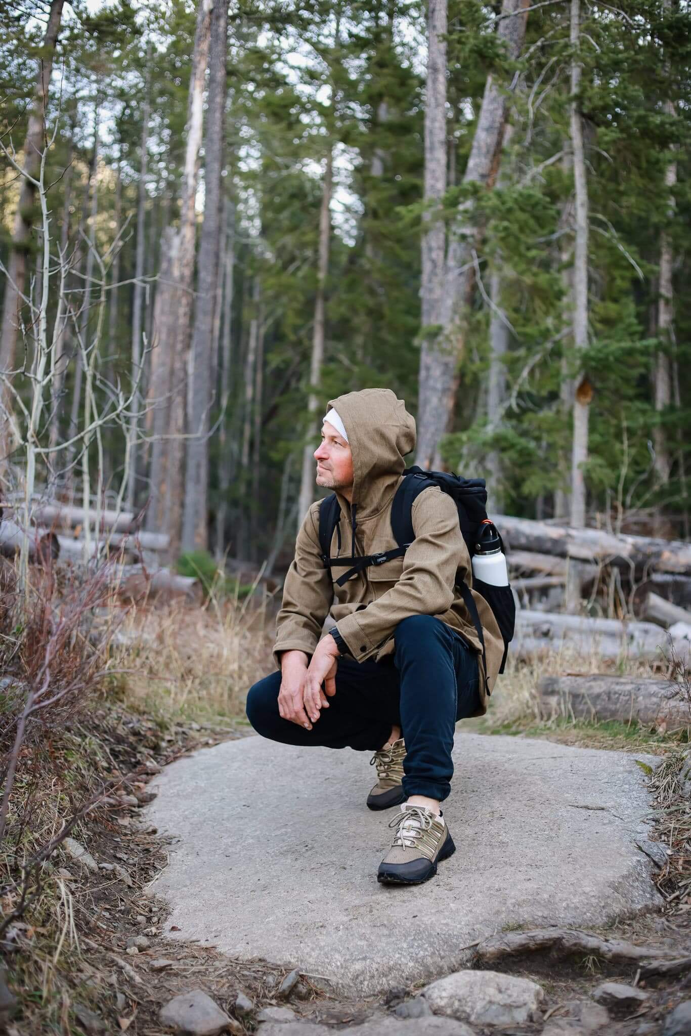 Man kneeling down while hiking wearing Dakota Grounding Trail Shoe in Khaki and Creme