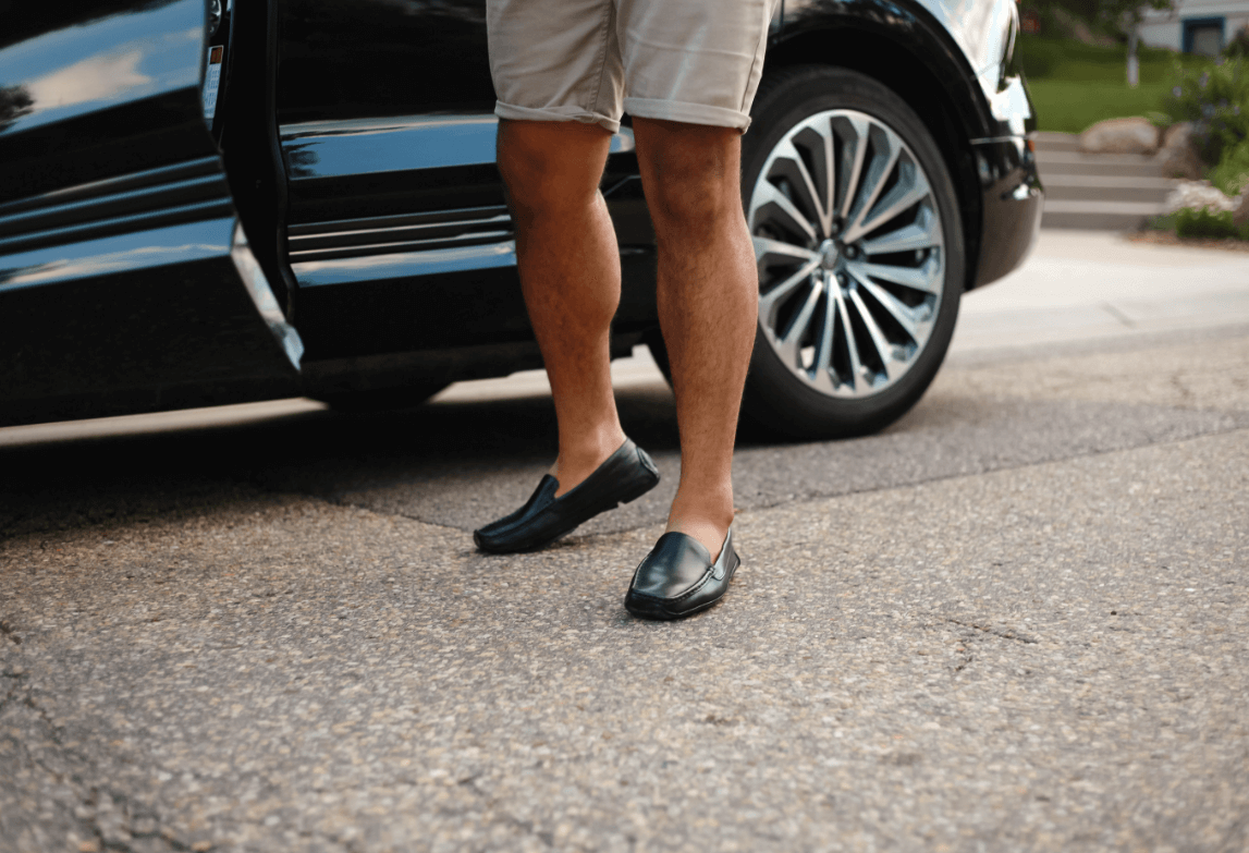 Man exiting car wearing black leather grounding drivers