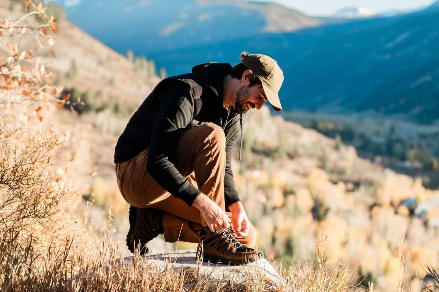 Man Tying Shoelaces of Jesse high Top Grounding Brown Leather Trail Shoe while hiking