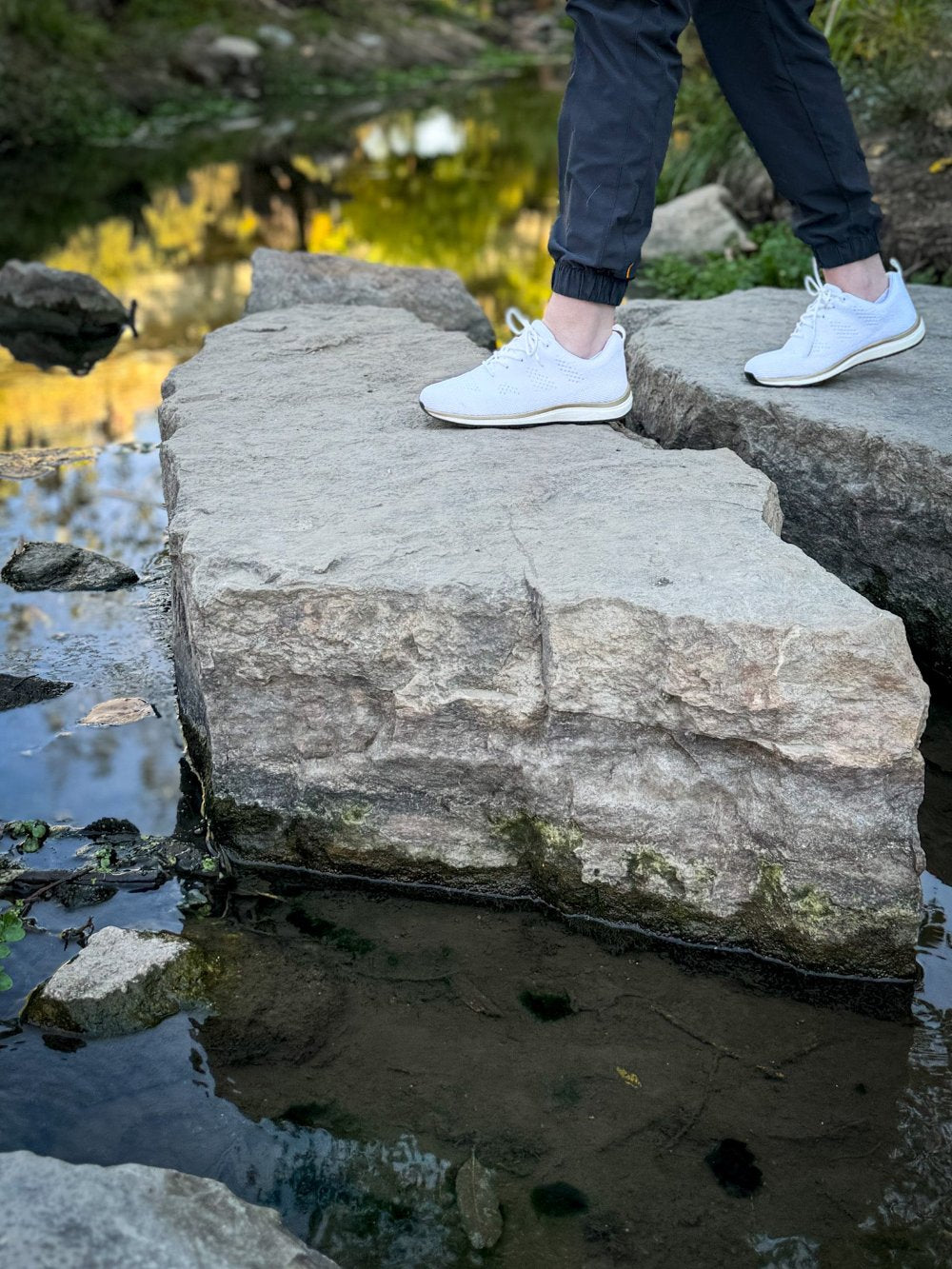 Woman wearing white and gold grounding lace-ups near river