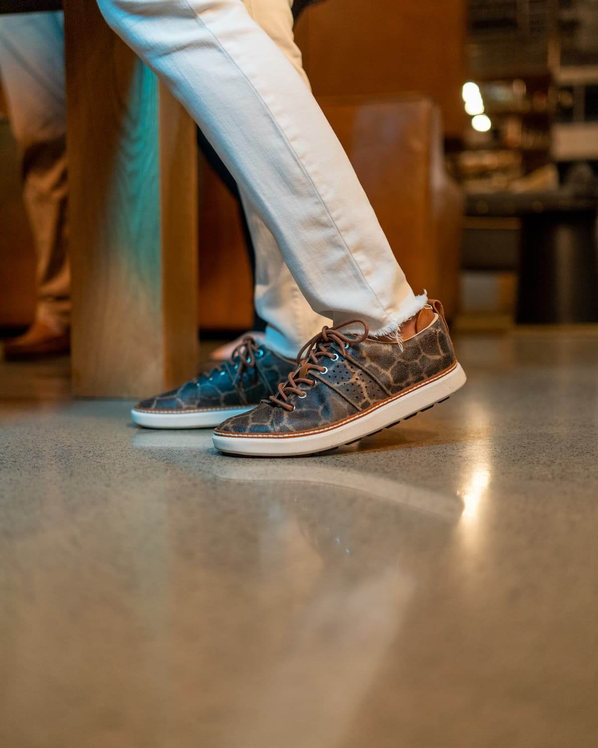 Woman wearing white pants and giraffe leather grounding walking shoe