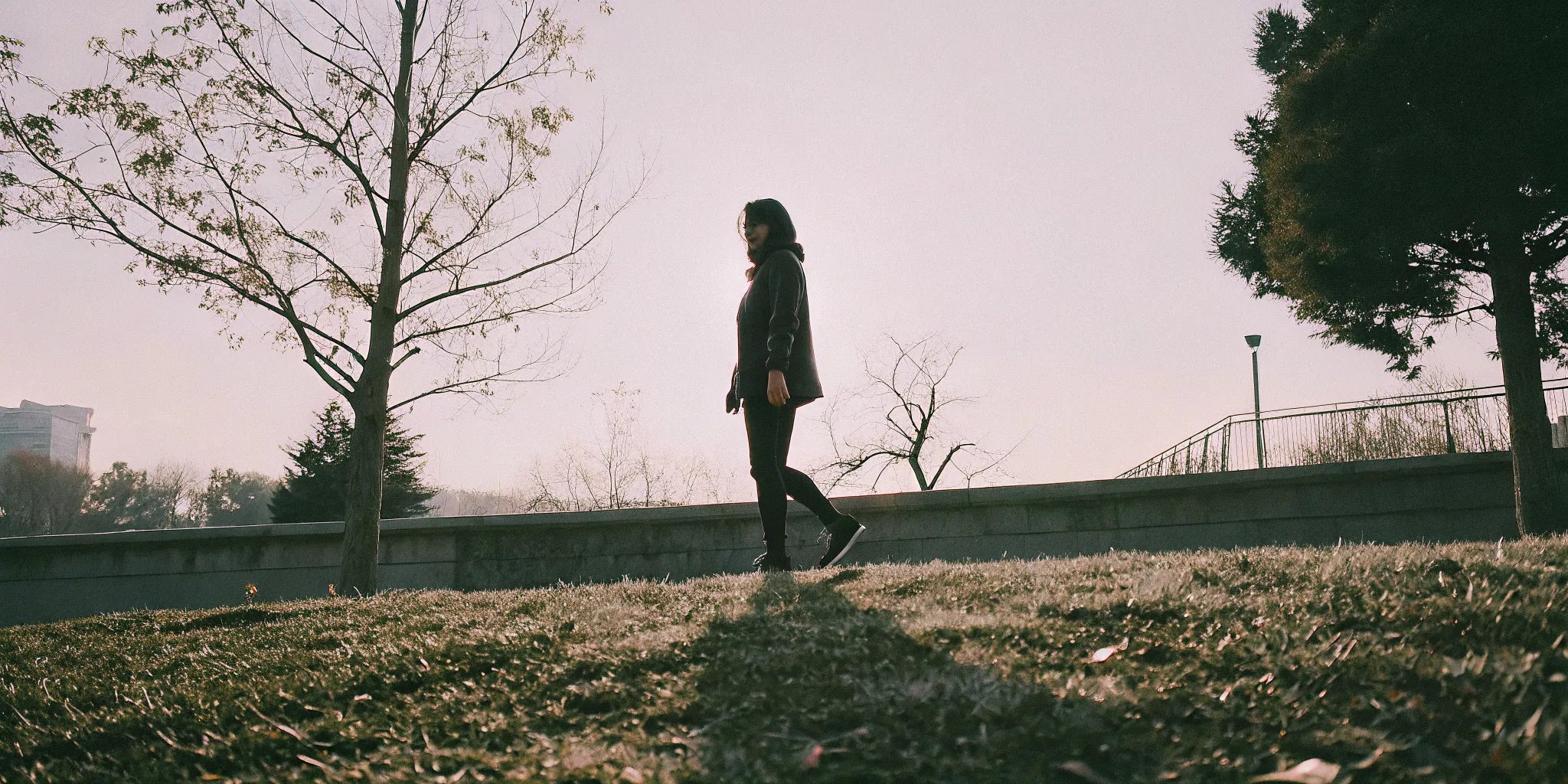Woman wearing grounding shoes walking on grass in a sunlit park