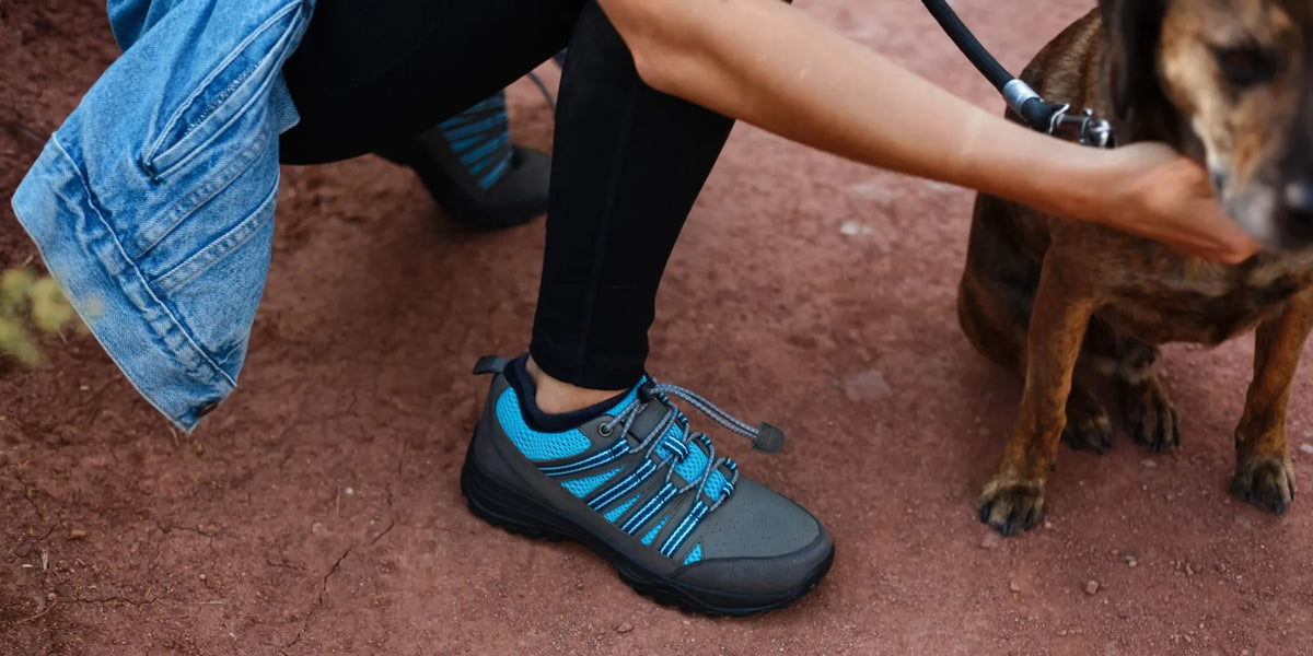 Close view of conductive grounding socks beside everyday shoes on a natural wood floor
