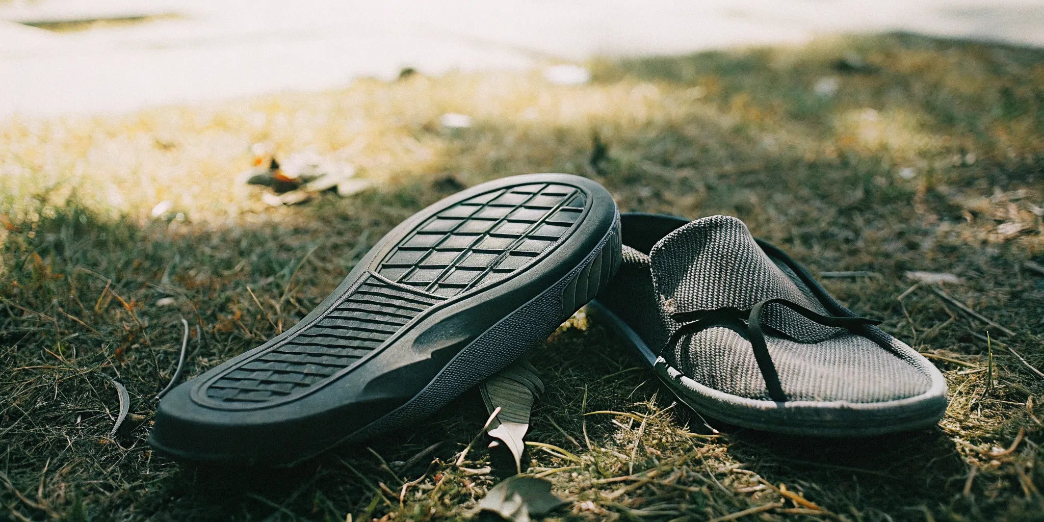 Stylish grounding shoes on grass in natural sunlight showing the conductive sole connecting to the earth