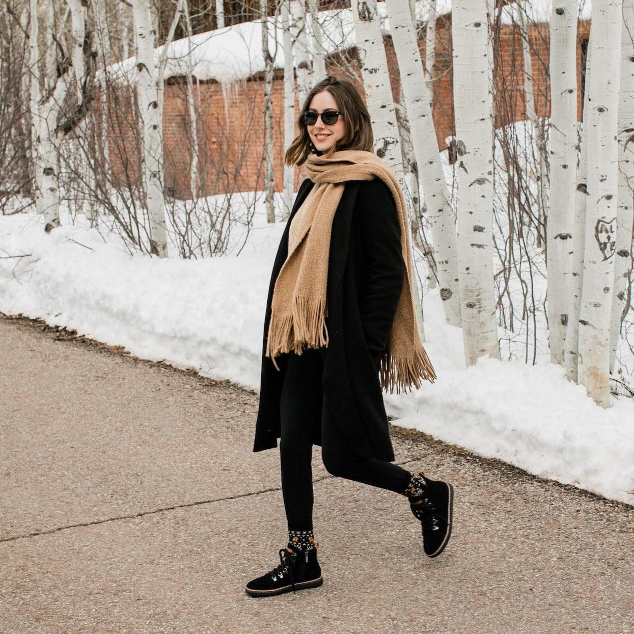 Woman wearing festive grounding crew socks and grounding black quilted high-top in winter