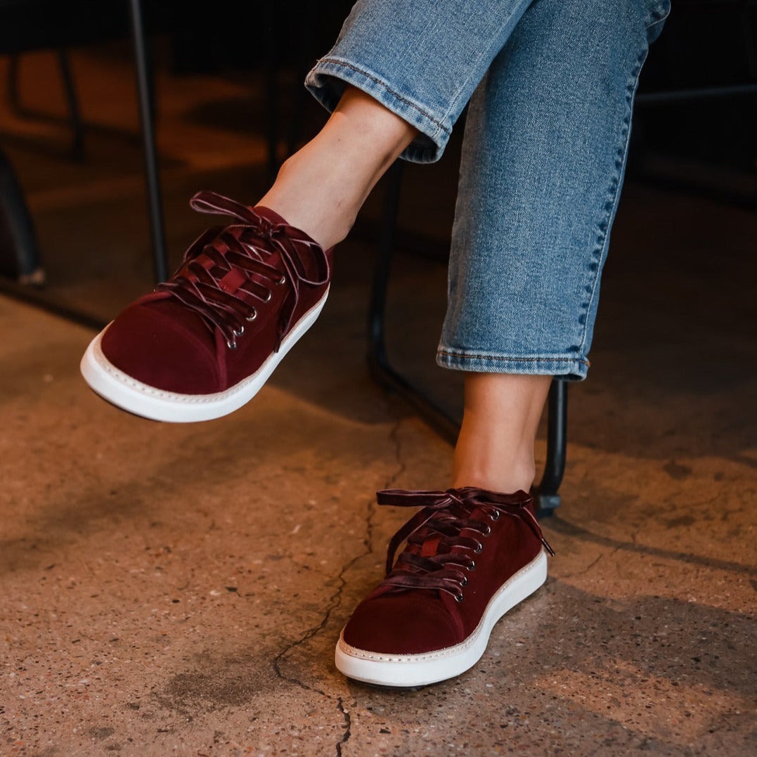 Woman wearing cabernet grounding suede walkers on unsealed concrete