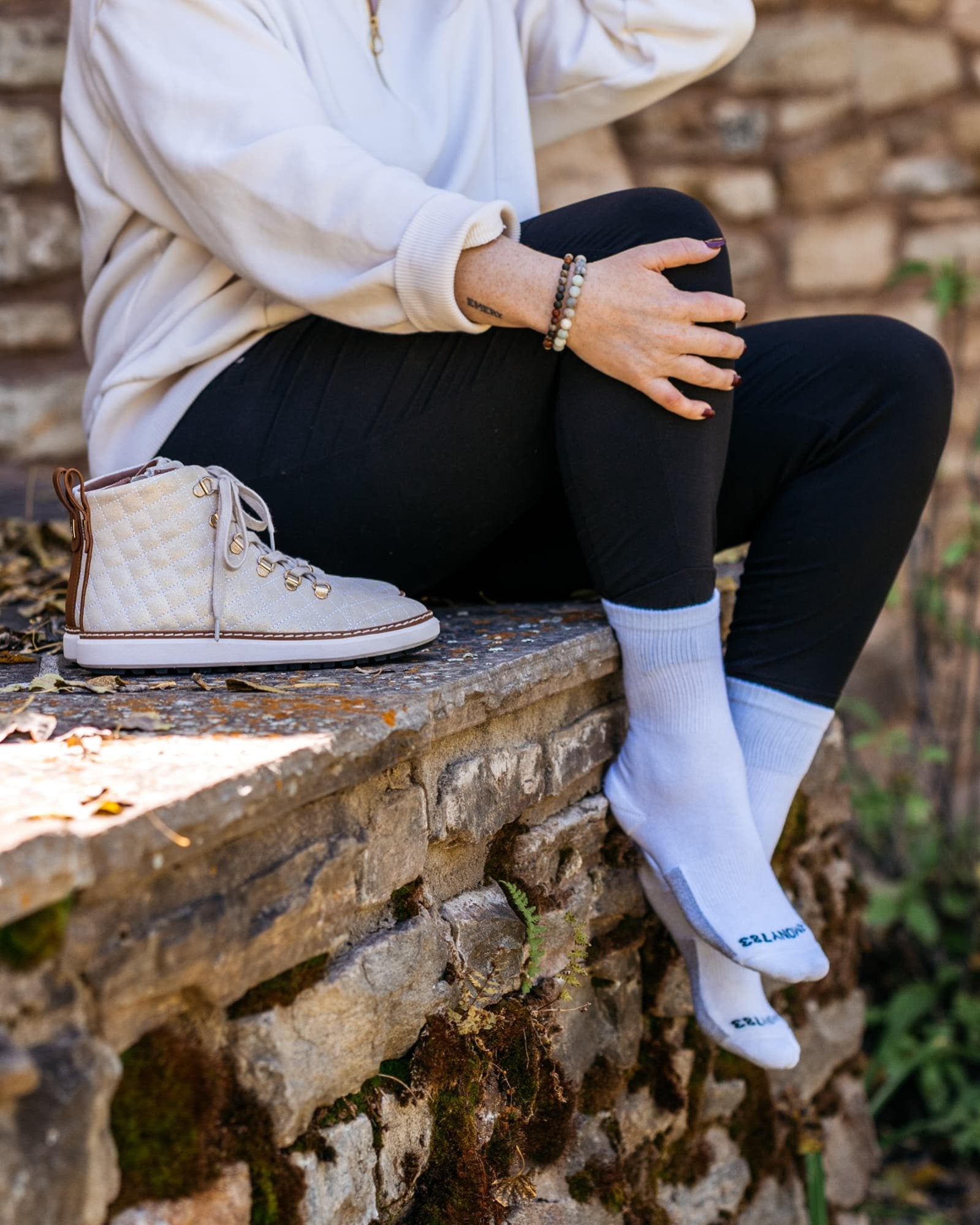 Close up o fwoman Sitting on stoneledge wearing Harmony 783 Crew Style Grounding Socks White Organic Cotton with Silver Stitching conductive earthing socks 
Lifestyle1