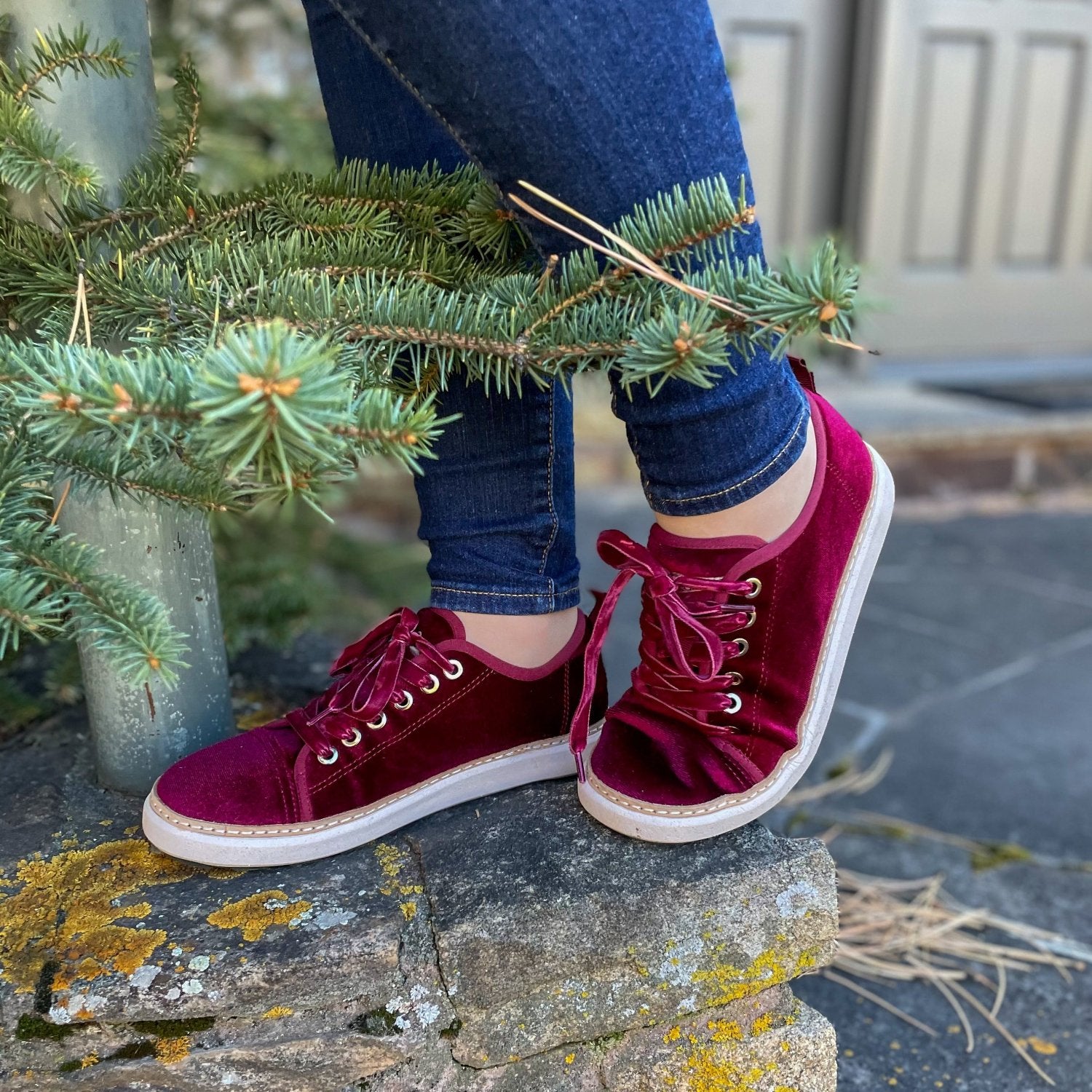 Woman standing on stone near pine tree wearing red bordeaux velvet grounding walkers