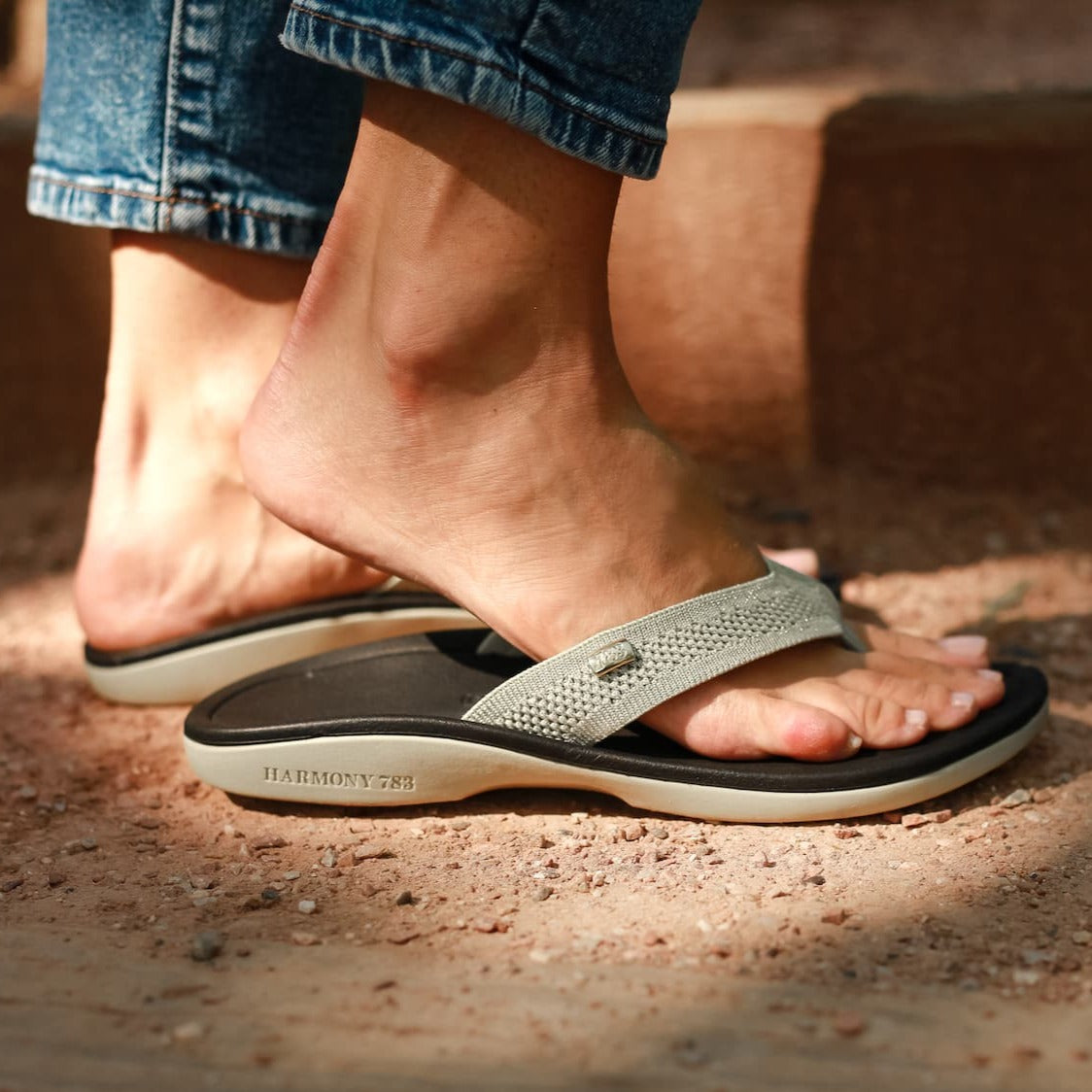 Close up of standing on dirt wearing Harmony 783  tatum platinum knit sandal conductive
footbed earthing 