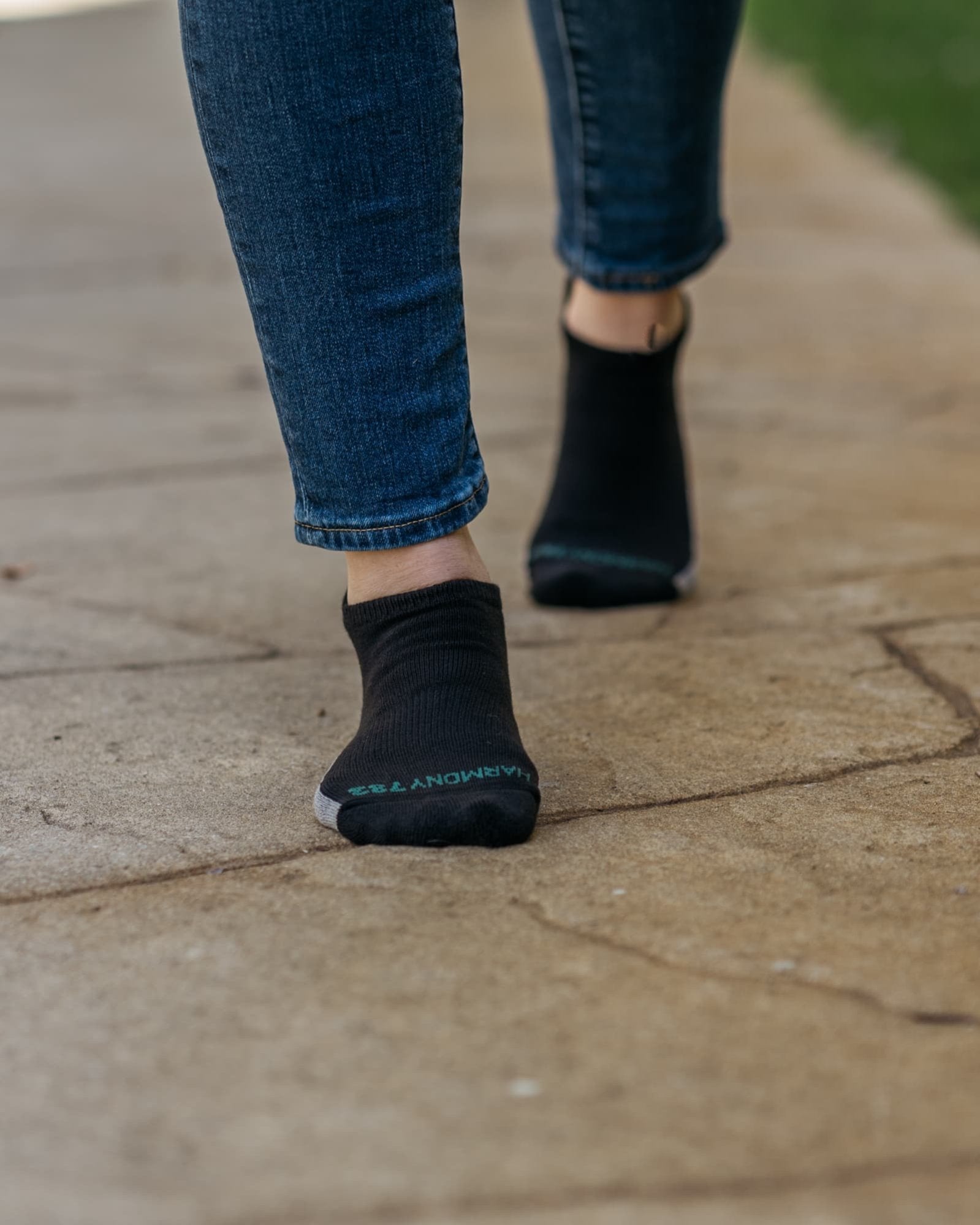 Close up of woman Walking on stone wearing Harmony 783 Grounding Socks Black Organic Cotton with Silver Stitching conductive earthing socks Lifestyle