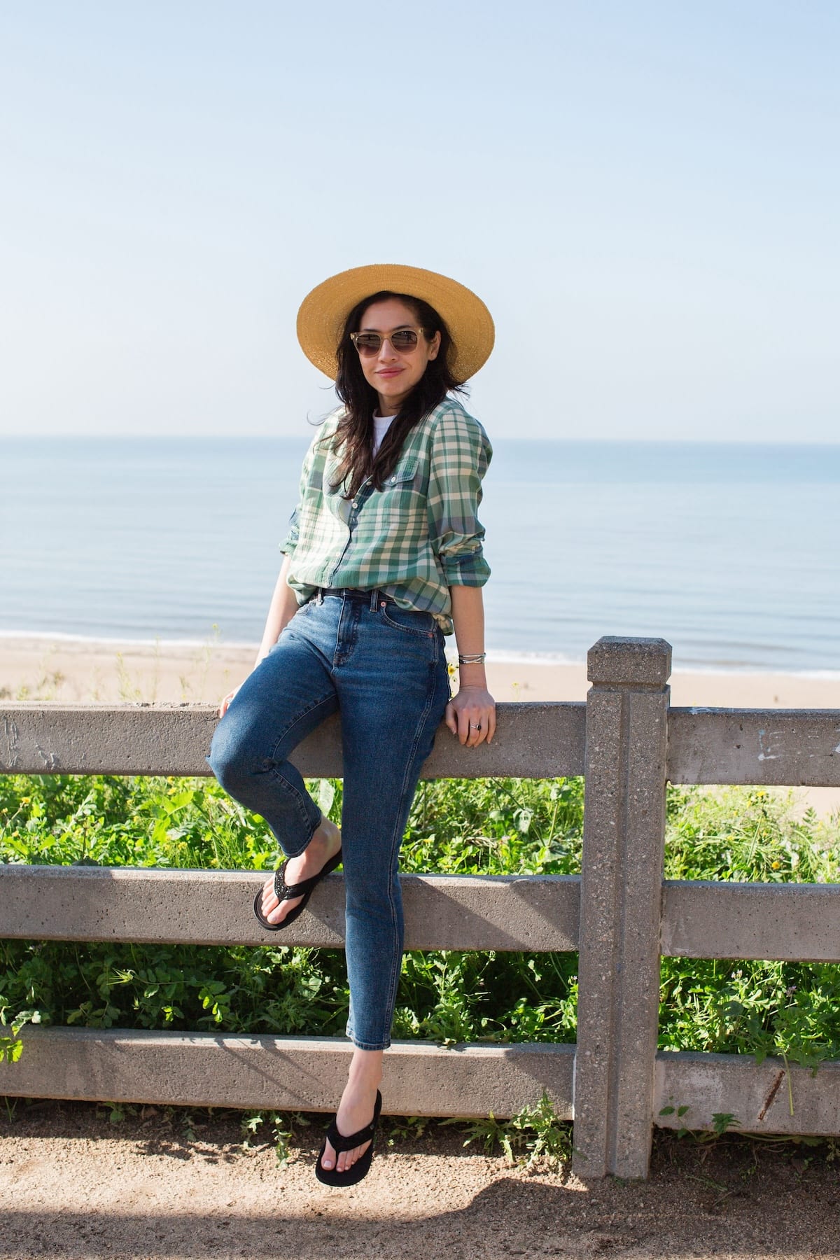 Woman in green plaid shirt and blue jeans with hat Sitting on fence in front of the ocean wearing Harmony 783 Stella Womens Grounding Conductive Earthing Sandal in Black Shimmer Suede Flip Flop
Lifestyle