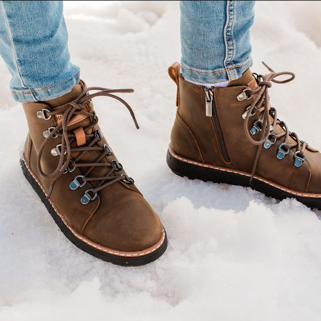 Woman standing in the snow wearing brown leather grounding boots