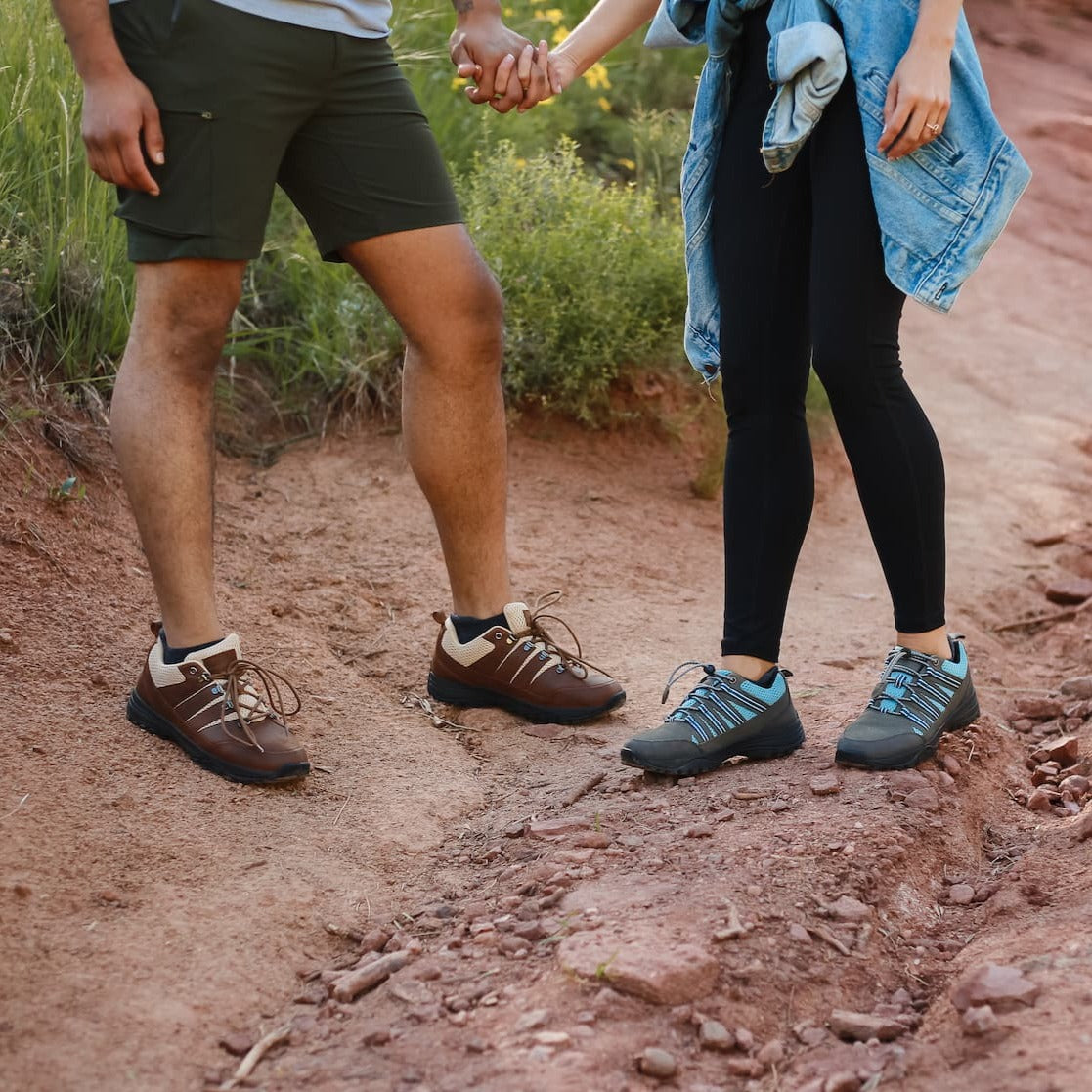 Man and woman holding hands while wearing grounding trail shoes for earthing on the trail