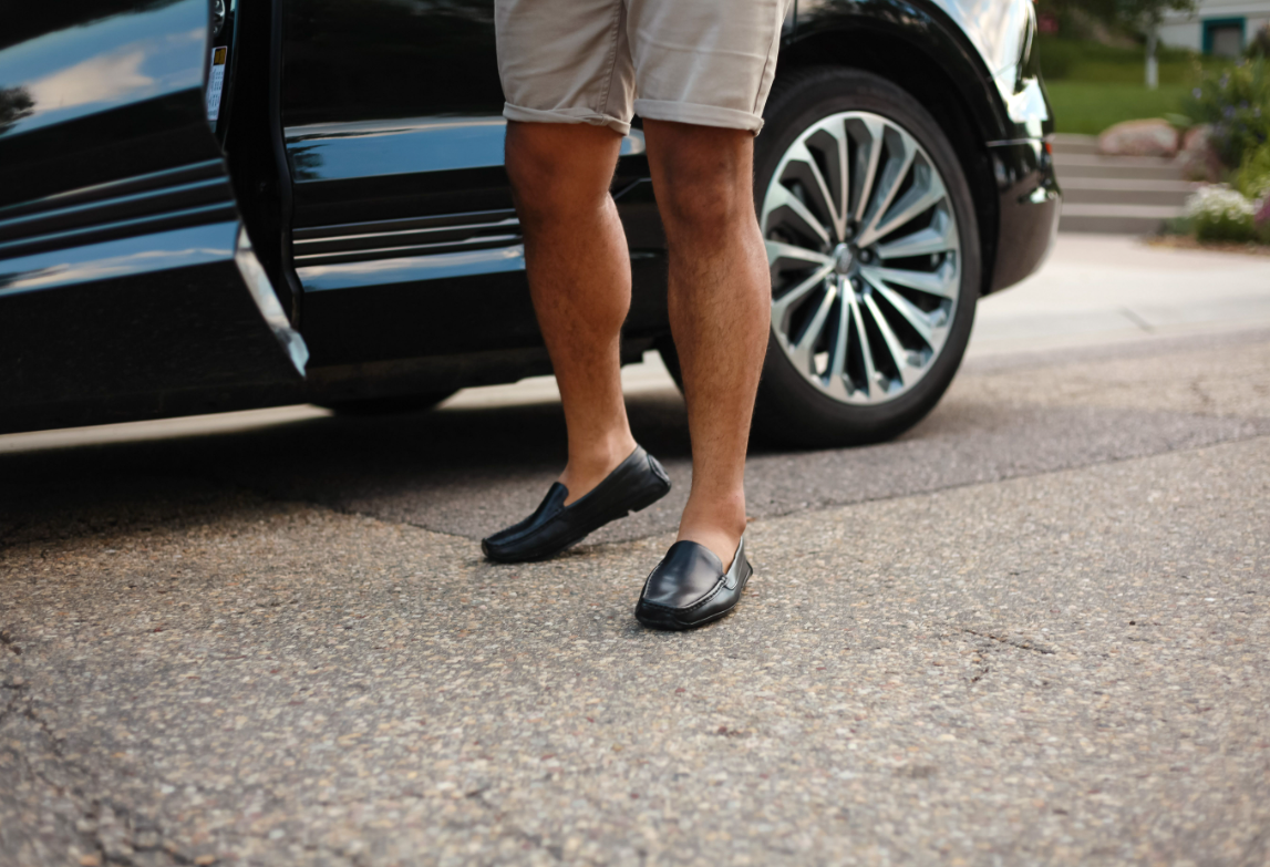 Man exiting car wearing black leather grounding drivers