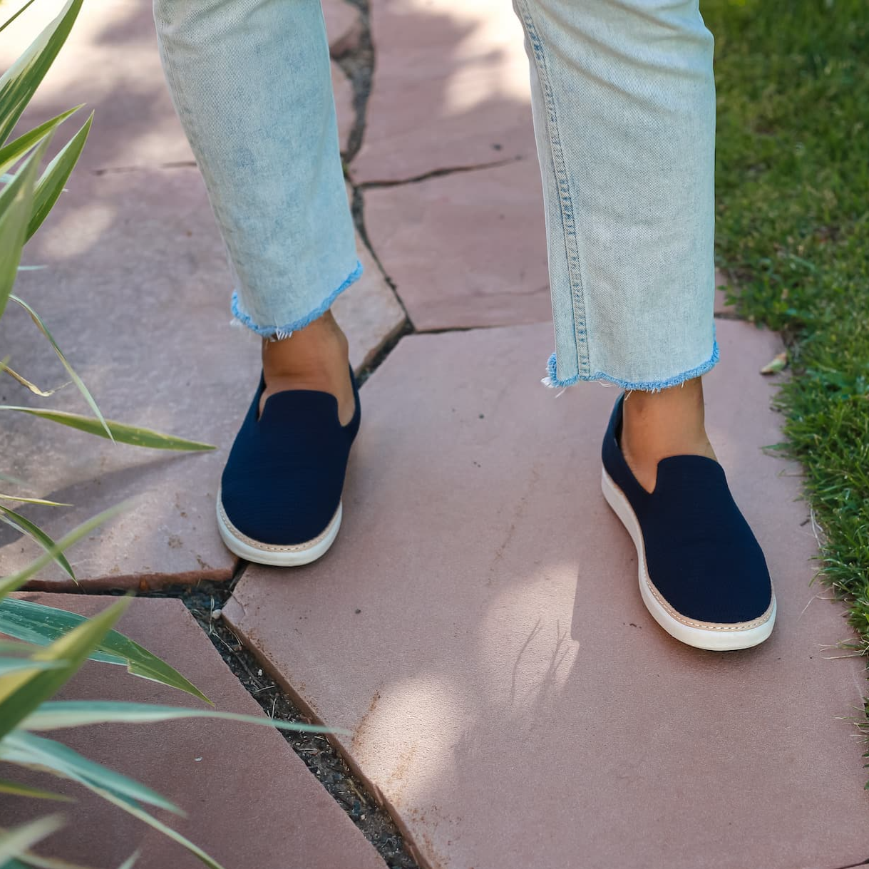 Men wearing Navy Bamboo Grounding Slip On and jeans near grass