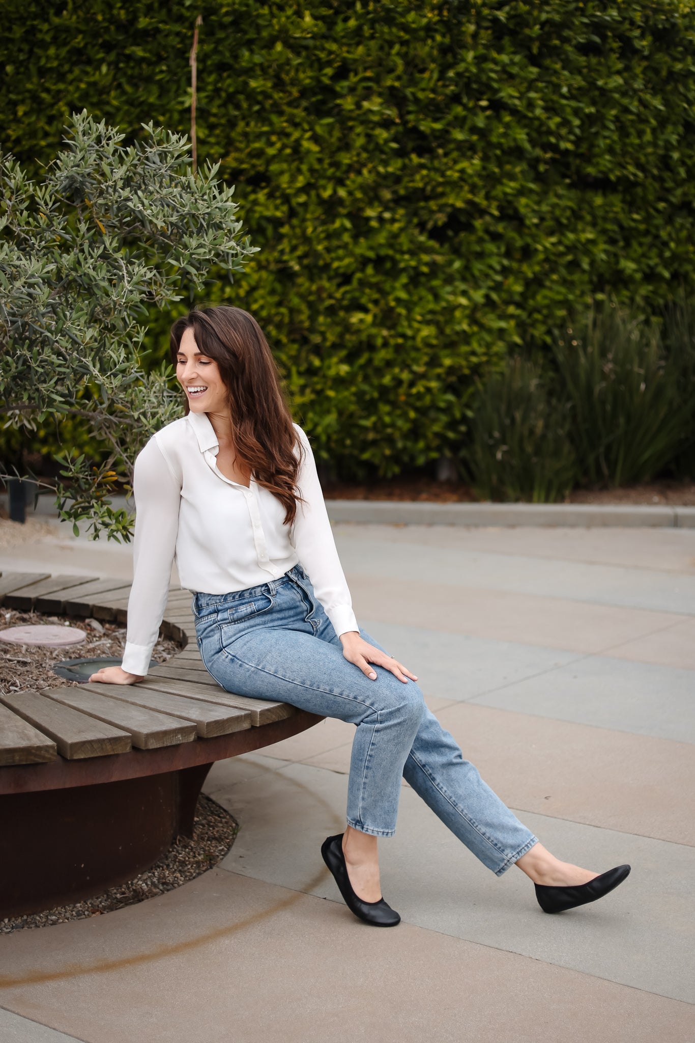 Woman sitting in park wearing black leather grounding ballet flats 