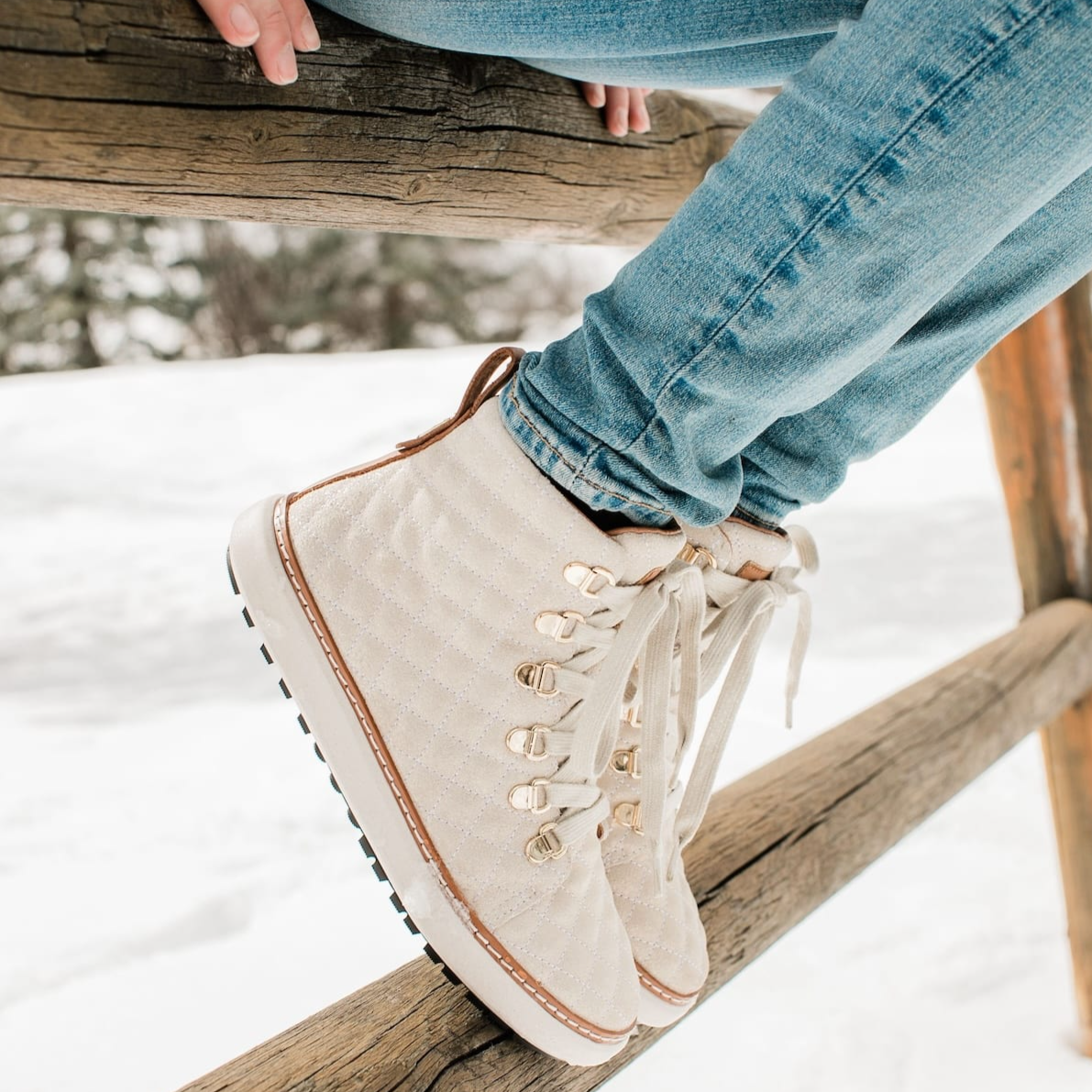 Woman wearing gold creme sparkling grounding high-top in winter near snow