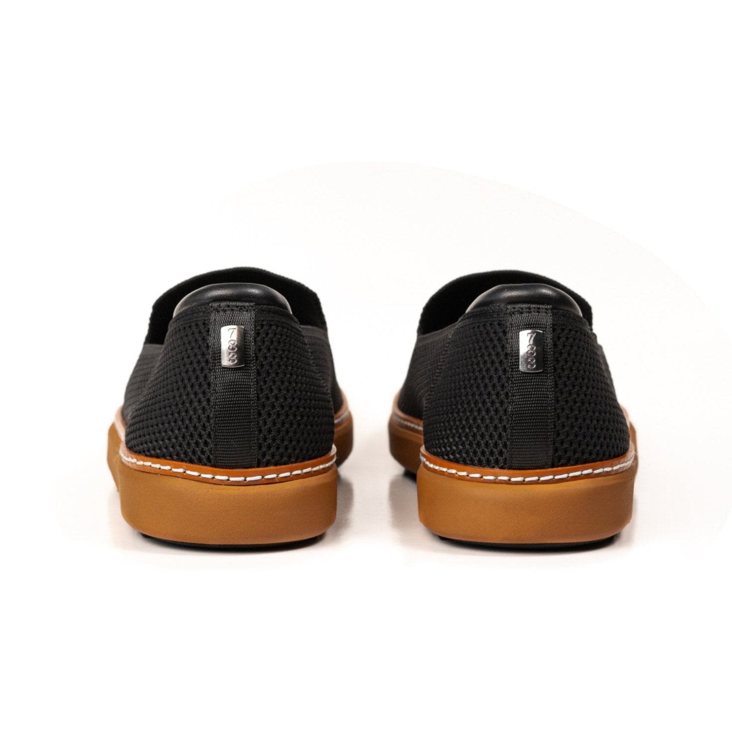 Heel view of black and cognac bamboo knit grounding slip-ons for men and women