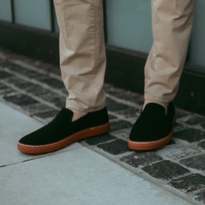 Man wearing Black and Cognac slip-ons on stone and concrete