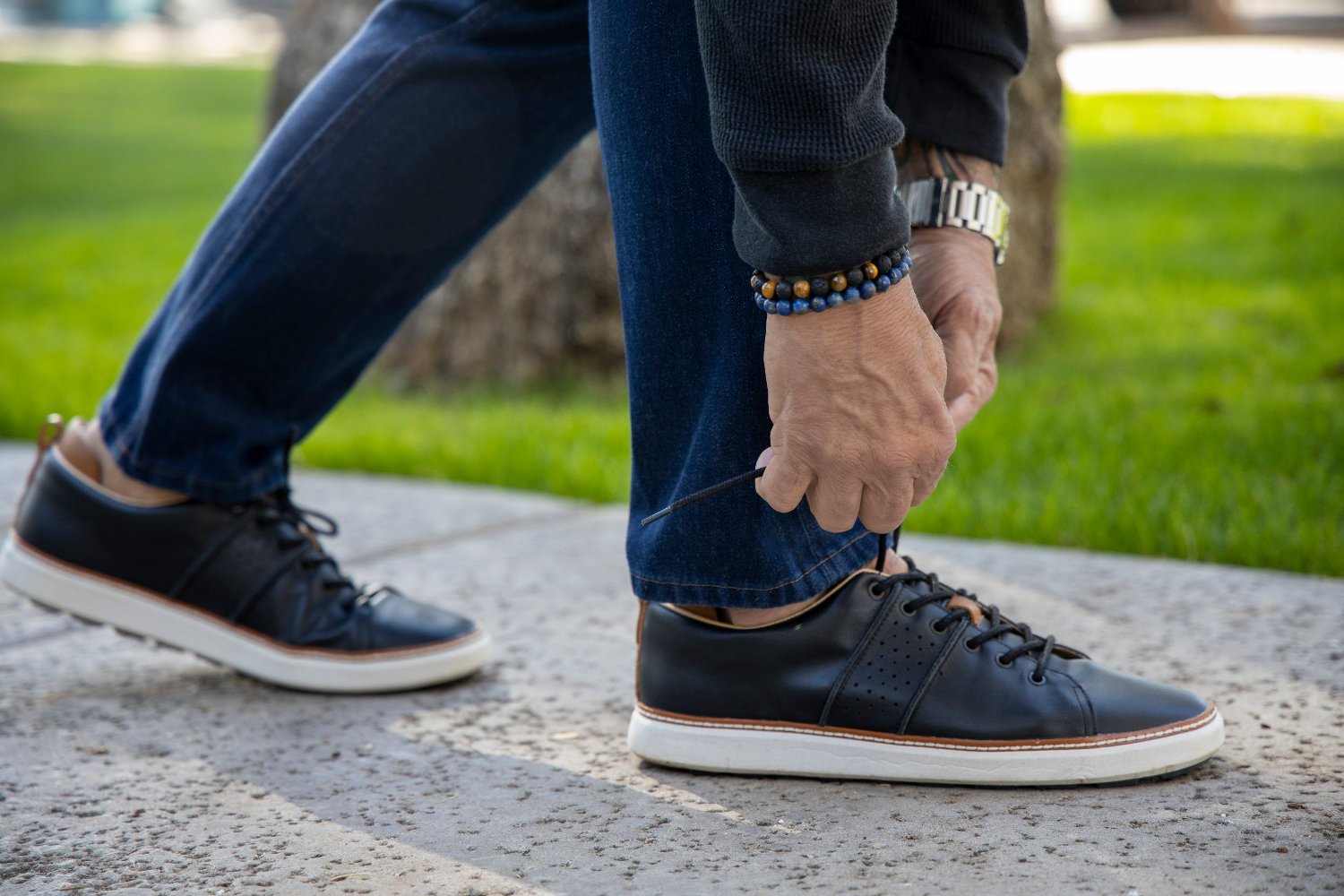 man tying shoelaces of black leather grounding walkers