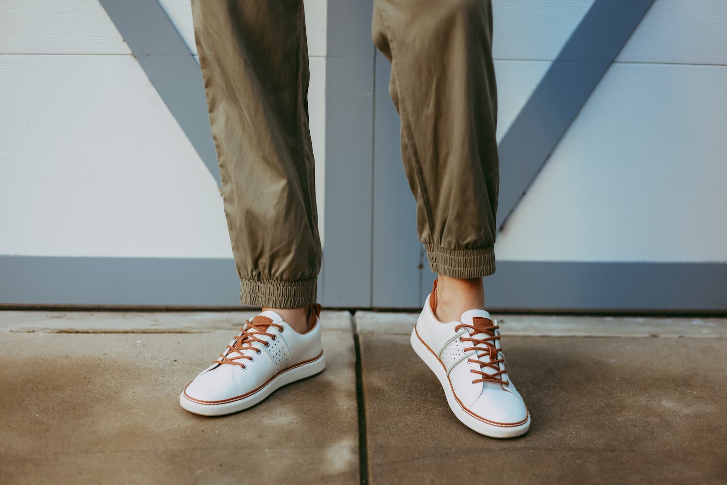 Close up of woman wearing green pants and white leather grounding shoes